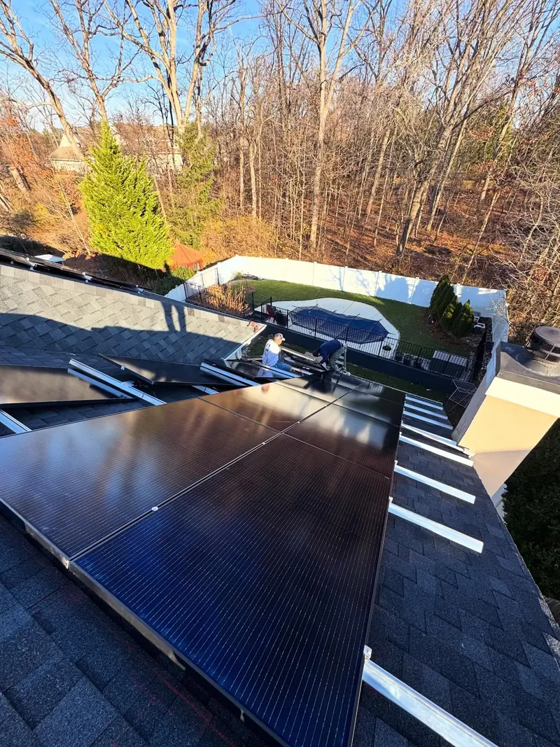 Energetic Electric crew installing solar panels on a home with a backyard pool